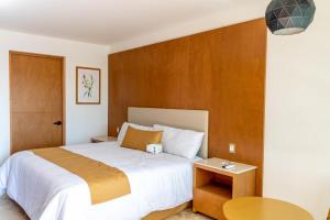 Rancho de la CruzHotel 5 Inn Select的卧室里有一张带木质床头板的大床