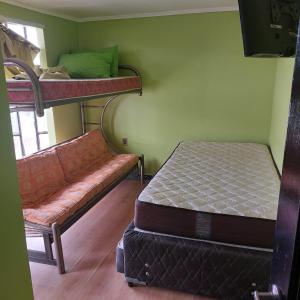 Coco Cris Hostal في كوكيمبو: غرفة نوم مع سريرين بطابقين وأريكة