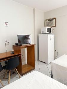 a room with a desk and a white refrigerator at Apart Hotel em Brasília - Garvey Park Hotel in Brasilia