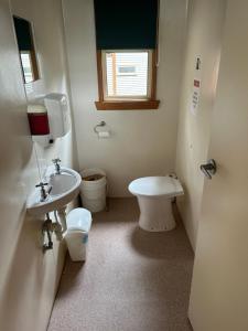 a small bathroom with a toilet and a sink at Base Camp Tasmania in New Norfolk