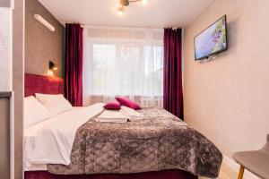 a bedroom with a bed with red curtains and a window at MYFREEDOM Апартаменти пр-т Воскресенський in Kyiv