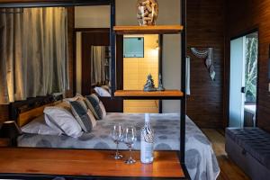 a bedroom with a bed with two glasses on a table at La Bella Vista in Urubici