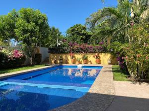 una piscina frente a una casa con flores en Zandoyo Bed & Breakfast en Puerto Escondido