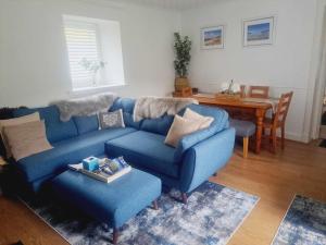 a living room with a blue couch and a table at Cliff Cottage in Valtos