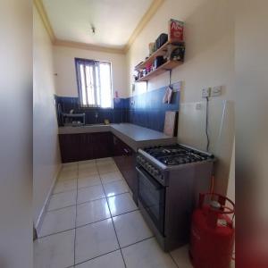 eine kleine Küche mit einem Herd und einem Kühlschrank in der Unterkunft Oasis Apartments in Mombasa