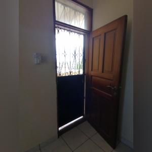 eine offene Tür in einem Zimmer mit Fenster in der Unterkunft Oasis Apartments in Mombasa