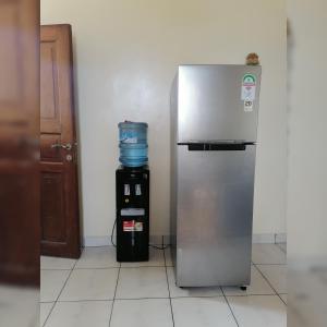 einen Kühlschrank und einen Wasserkühler in einem Zimmer in der Unterkunft Oasis Apartments in Mombasa