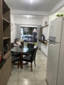 uma cozinha e sala de jantar com uma mesa e um frigorífico em Aconchegante Casa de praia em Matinhos