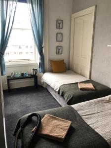 1 Schlafzimmer mit 2 Betten und einem Fenster in der Unterkunft THE EDINBURGH TOWNHOUSE - Boutique Hostel in Edinburgh