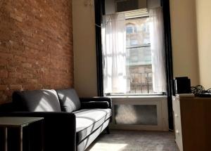 a living room with a couch and a window at Elegant 1BR Apartment in NYC! in New York