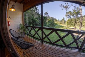 a porch with two chairs and a large window at La Bella Vista in Urubici