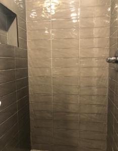 a bathroom with a shower with tiled walls at Elegant 1BR Apartment in NYC! in New York