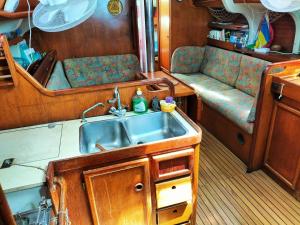 a kitchen with a sink and a couch in a boat at Boat Vogue à Lame in Gourbeyre