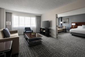 a hotel room with a bed and a living room at Bakersfield Marriott at the Convention Center in Bakersfield