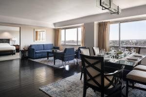 a living room with a dining table and a room with a view at Bakersfield Marriott at the Convention Center in Bakersfield