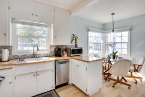 a kitchen with white cabinets and a table with chairs at Huntington Beach Hideaway Near Beach and Downtown! in Huntington Beach