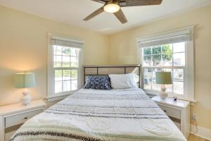 a bedroom with a large bed with two windows at Huntington Beach Hideaway Near Beach and Downtown! in Huntington Beach
