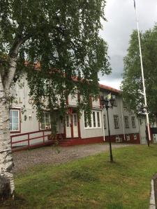 a large white house with a tree in front of it at Hotel Akerlund in Jokkmokk