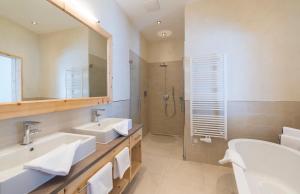 a bathroom with two sinks and a shower at Hotel Grünauerhof in Wals