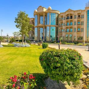 un gran edificio con un césped verde delante de él en Ramage Hotel & Resort en El Cairo