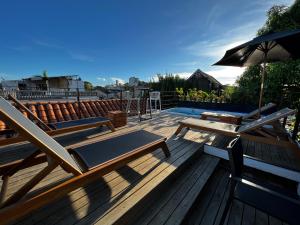 a wooden deck with benches and an umbrella at Los Patios Hostel in Cartagena de Indias