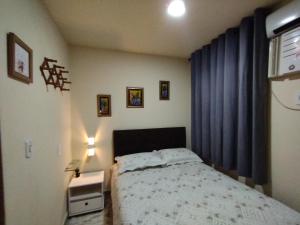 1 dormitorio con cama y cortina azul en Loft em Cobertura, en Río de Janeiro