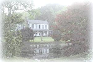 a large white house with a reflection in the water at Historic Seaton Springs Farm B&B - M Seaton Queen Room with Private Bath down the hall in Sevierville