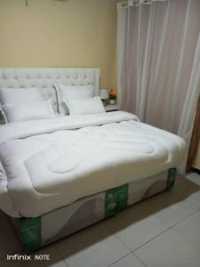 duże białe łóżko w sypialni w obiekcie Planet Golf - foxdale w mieście Foxdale Estates