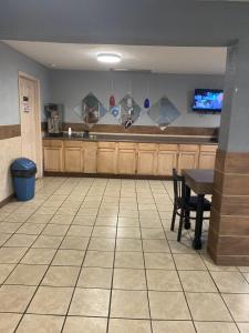 eine große Küche mit einem Tisch und einem TV in der Unterkunft Motel 6 Hurricane, WV in Hurricane