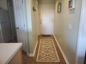 a hallway with a rug on the floor next to a door at Tilghman Shores D9 in Myrtle Beach