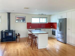 a kitchen with white cabinets and a stove at Eildon Views in Bonnie Doon