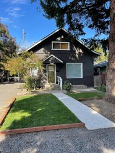 una casa negra con un patio de hierba delante de ella en Classic & Cozy Apartments - Parking & Close To Dw, en Medford