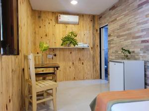 a kitchen with wooden walls and a table and a refrigerator at Casa de Dan in Pipa