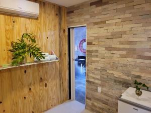 a bathroom with a brick wall and a door at Casa de Dan in Pipa