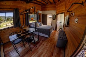 a bedroom with a bed and a desk in a room at La Bella Vista in Urubici