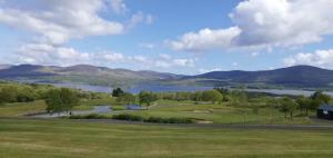 a golf course with a lake and mountains in the background at Beautiful Holiday Cottage near Kenmare in Kenmare