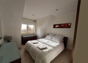 a bedroom with a white bed and a window at Beautiful Holiday Cottage near Kenmare in Kenmare