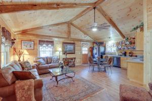 uma sala de estar com um sofá e uma mesa em Tumbling Shoals Cabin with Fire Pit 1 Mi to Lake em Heber Springs
