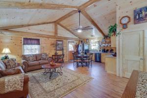 uma sala de estar com um sofá e uma mesa em Tumbling Shoals Cabin Near Greers Ferry Lake! em Heber Springs