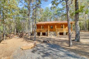 uma cabana de madeira na floresta com um grande alpendre em Tumbling Shoals Cabin Near Greers Ferry Lake! em Heber Springs