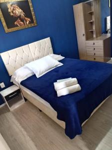 um quarto azul com uma cama com toalhas em Hospedagem D´Roos em Canela