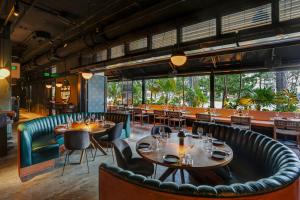 a restaurant with tables and chairs and a large window at Urbanica Euclid in Miami Beach