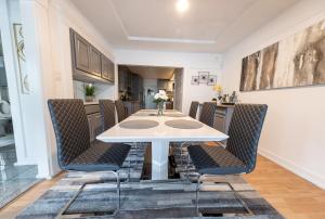 Cityscape Haven - Central SF Home near SFO في سان برونو: غرفة طعام مع طاولة بيضاء وكراسي