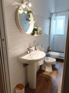 uma casa de banho com um lavatório, um WC e um espelho. em La Casa di Niky em Bracciano