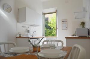 a kitchen with a table and chairs and a kitchen with a window at La Casa di Niky in Bracciano +15 photos