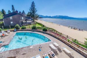 a swimming pool next to a beach and a house at Lakeland Village South Lake Tahoe in South Lake Tahoe
