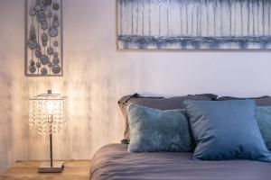 a bed with blue pillows and a lamp in a room at Cityscape Haven - Central SF Home near SFO in San Bruno