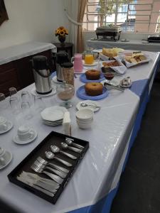 a long table with plates and utensils on it at Hotel Colonial in Cajati