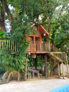 a tree house with a bench in front of it at Hotel Colonial in Cajati +16 photos