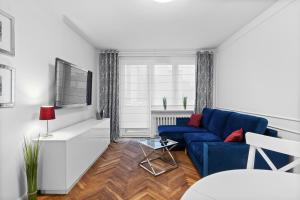 a living room with a blue couch and a window at Apartament Warszawa STARE MIASTO in Warsaw